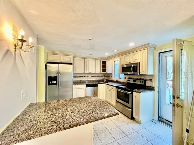 a kitchen with stainless steel appliances granite countertop a refrigerator and a sink