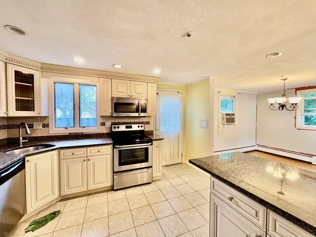 a kitchen with granite countertop a sink stainless steel appliances and cabinets