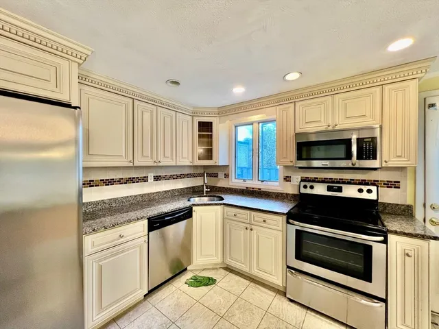 a kitchen with stainless steel appliances granite countertop a stove microwave and refrigerator