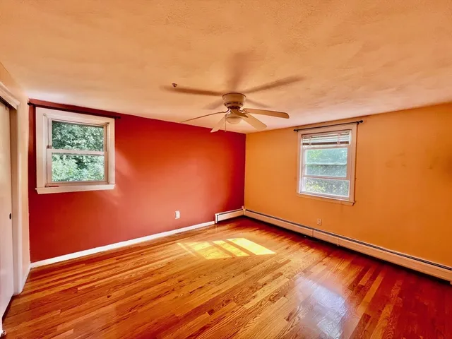 an empty room with a window and a ceiling fan