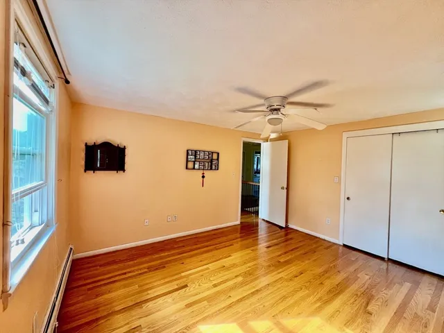 a view of a livingroom with wooden floor and a ceiling fan