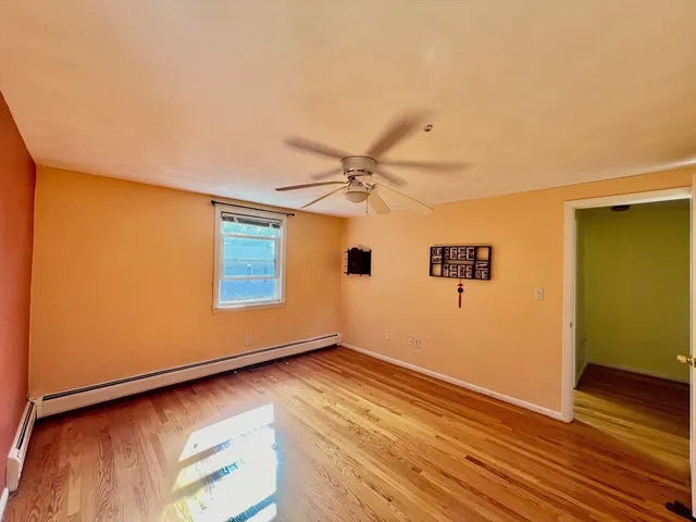 a view of a room with wooden floor and a ceiling fan