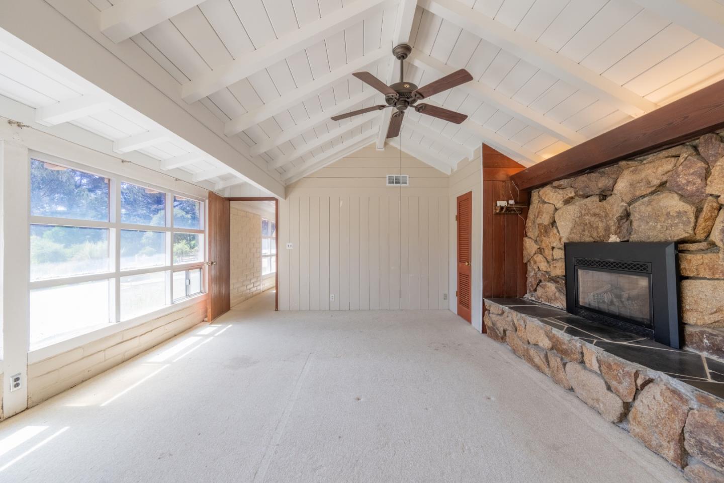 72 Los Laureles Grade Road Carmel Valley, CA 93924 - Photo 7 of 43 a view of an empty room with a fireplace and a window