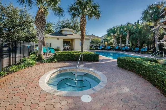 a view of a house with a yard and palm trees
