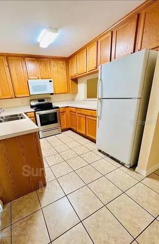 a kitchen with stainless steel appliances granite countertop a refrigerator sink stove and cabinets