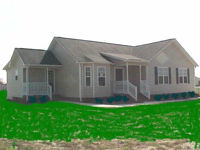 a front view of a house with a garden and yard