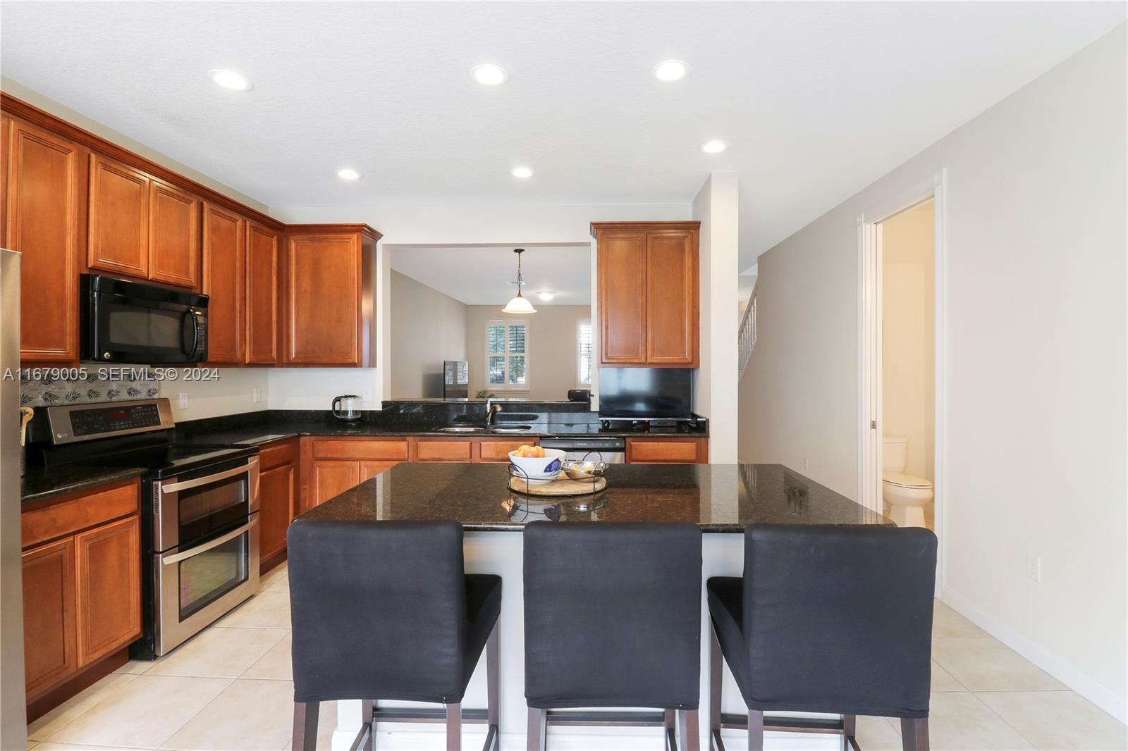 1184 Islamorada Drive, Unit 1184 Jupiter, FL 33458 - Photo 12 of 34 a kitchen with stainless steel appliances granite countertop a stove a sink a microwave a refrigerator and cabinets