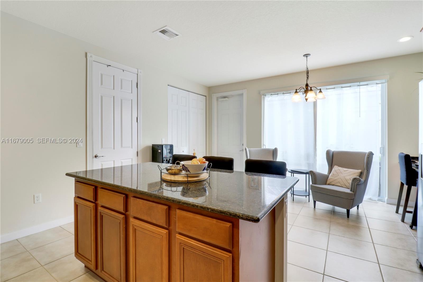 1184 Islamorada Drive, Unit 1184 Jupiter, FL 33458 - Photo 13 of 34 a kitchen with a table chairs and a refrigerator