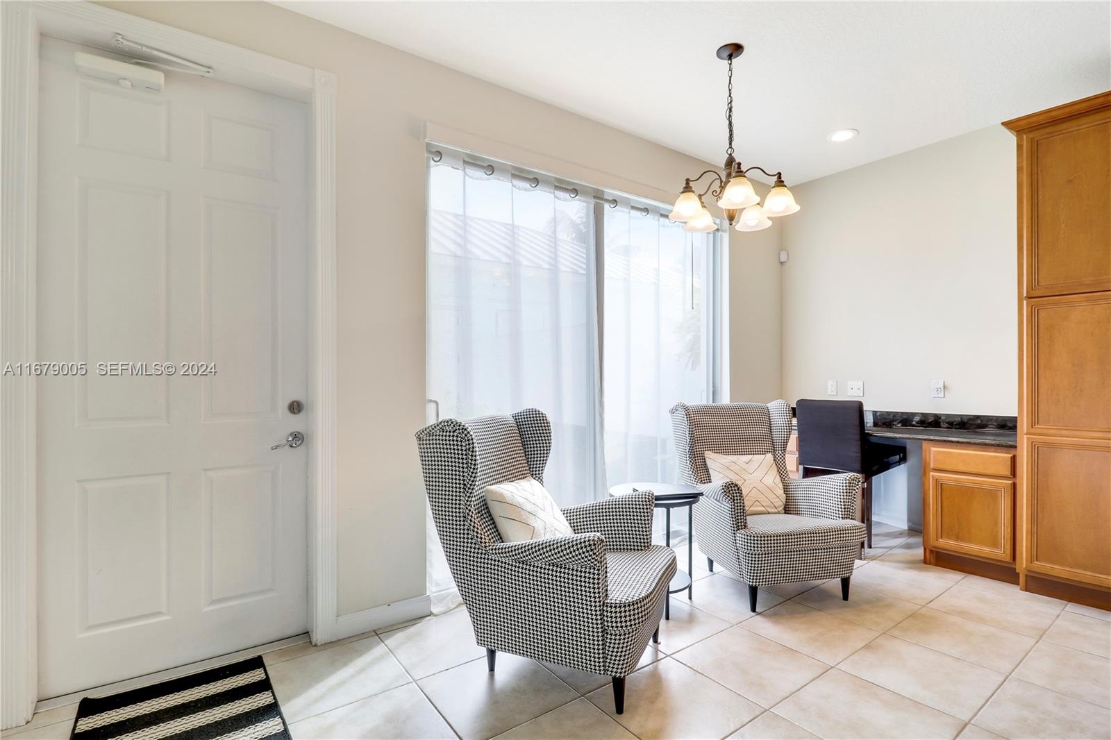 1184 Islamorada Drive, Unit 1184 Jupiter, FL 33458 - Photo 14 of 34 a living room with furniture a chandelier and a window
