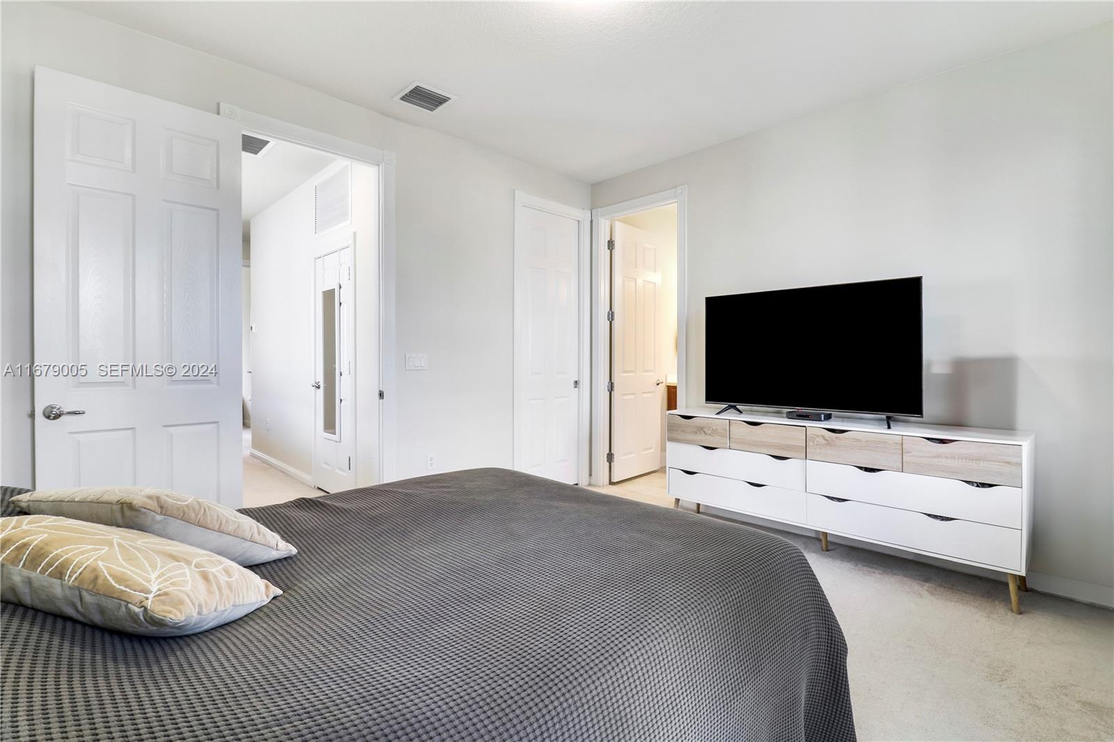 1184 Islamorada Drive, Unit 1184 Jupiter, FL 33458 - Photo 18 of 34 a bedroom with furniture and flat screen tv