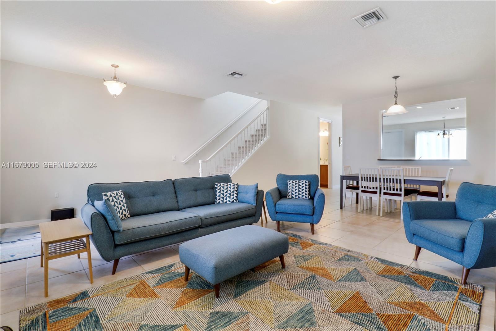 1184 Islamorada Drive, Unit 1184 Jupiter, FL 33458 - Photo 5 of 34 a living room with furniture a rug and a chandelier