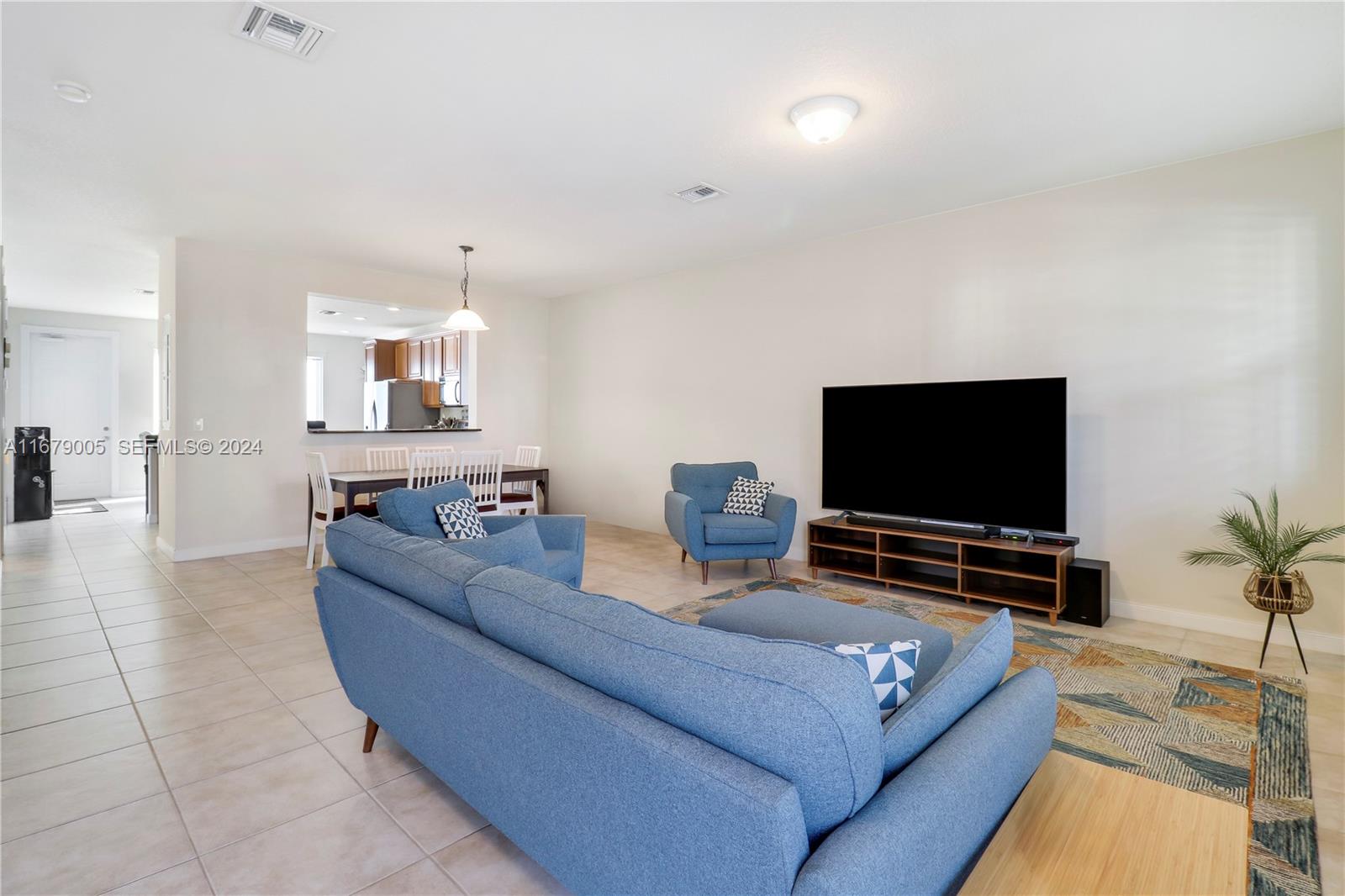 1184 Islamorada Drive, Unit 1184 Jupiter, FL 33458 - Photo 7 of 34 a living room with furniture and a flat screen tv