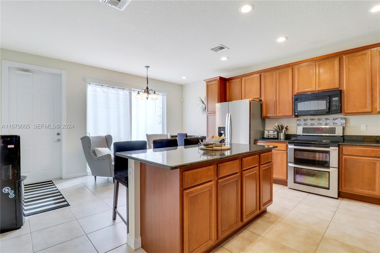 1184 Islamorada Drive, Unit 1184 Jupiter, FL 33458 - Photo 9 of 34 a kitchen with stainless steel appliances a stove refrigerator sink and cabinets
