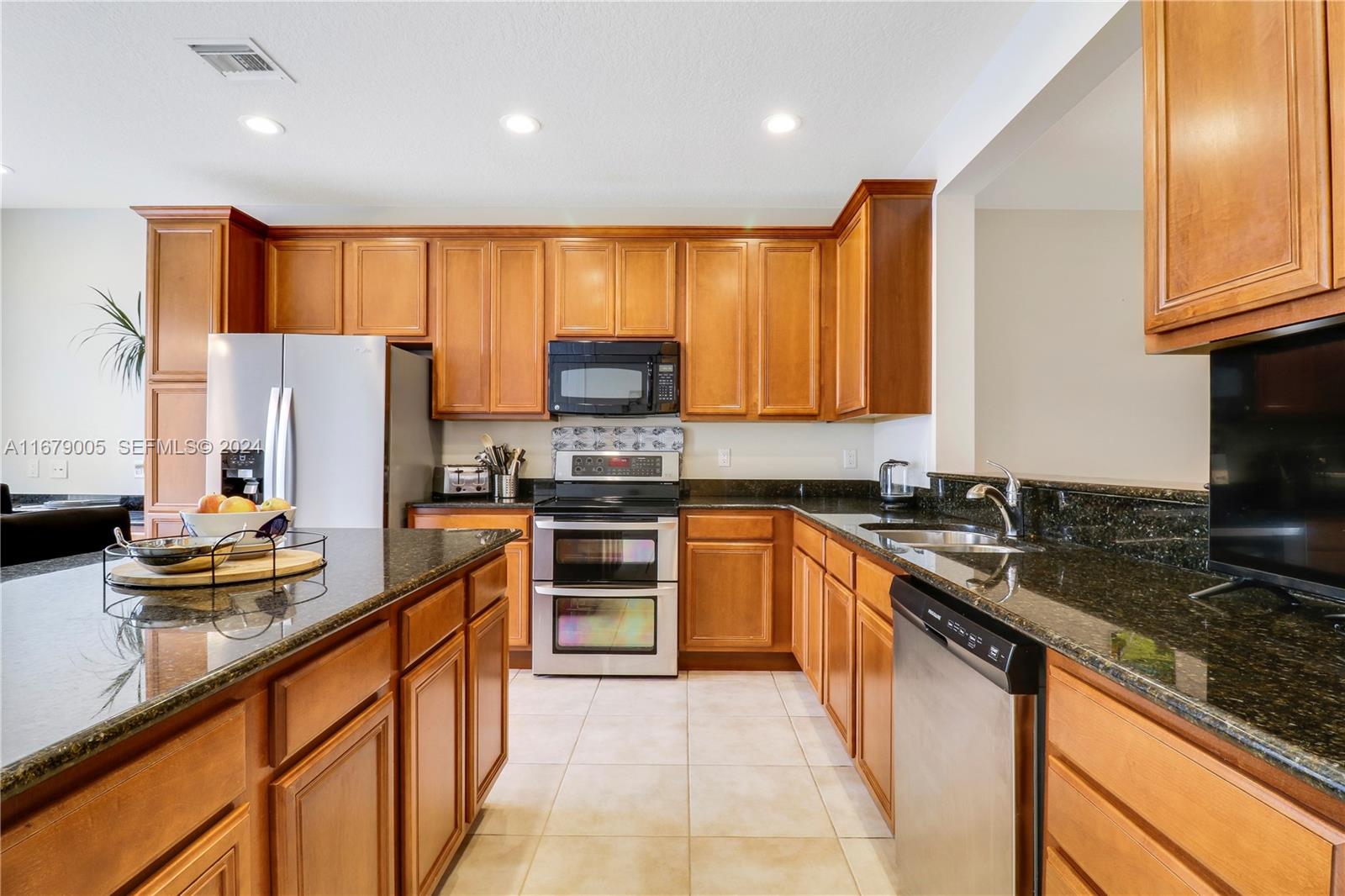 1184 Islamorada Drive, Unit 1184 Jupiter, FL 33458 - Photo 10 of 34 a kitchen with stainless steel appliances granite countertop a sink stove and refrigerator