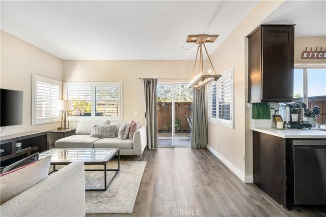 a living room with furniture a large window and wooden floor