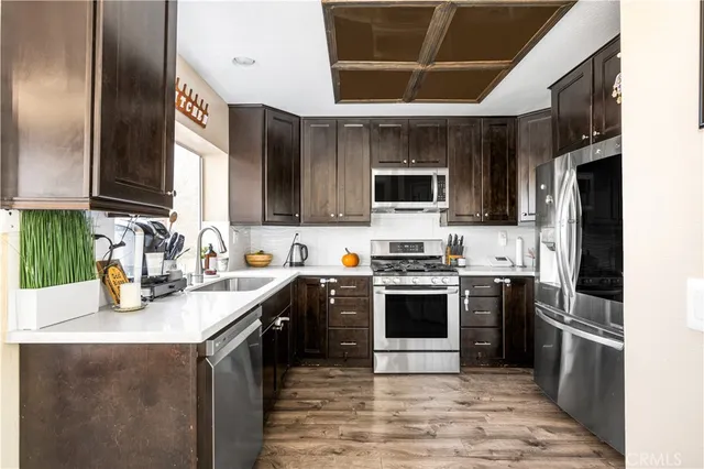 a kitchen with kitchen island granite countertop a stove sink microwave and refrigerator