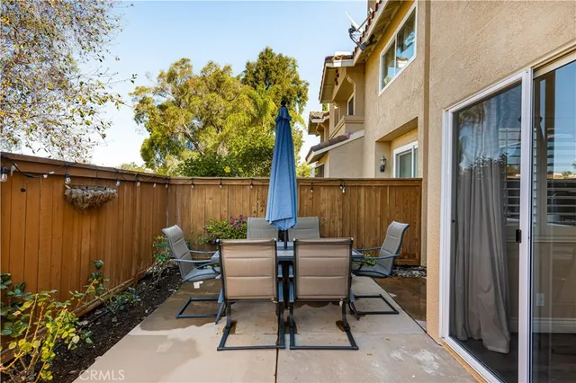 a view of a patio with table and chairs and potted plants with wooden floor and fence