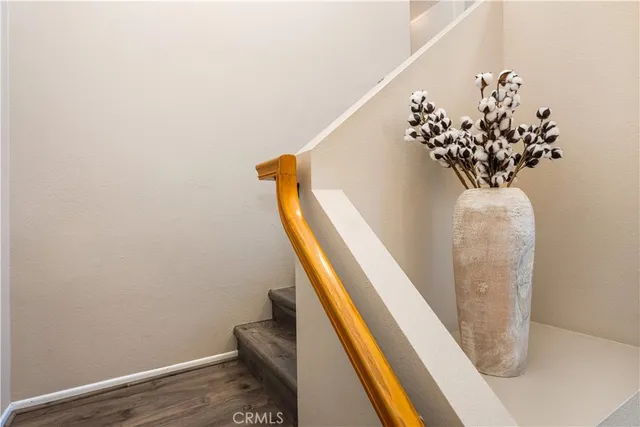 a view of a hallway with wooden floor and staircase