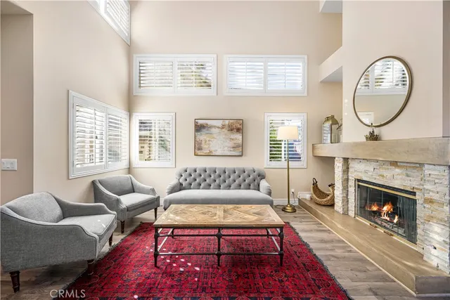 a living room with furniture a rug a fireplace with window