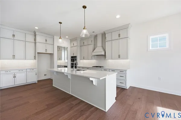 a kitchen that has a lot of cabinets in it and wooden floors