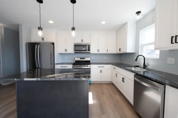 a view of a living room hardwood floor and a kitchen