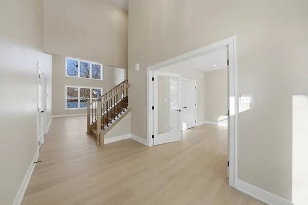 a view of a hallway with wooden floor and entryway