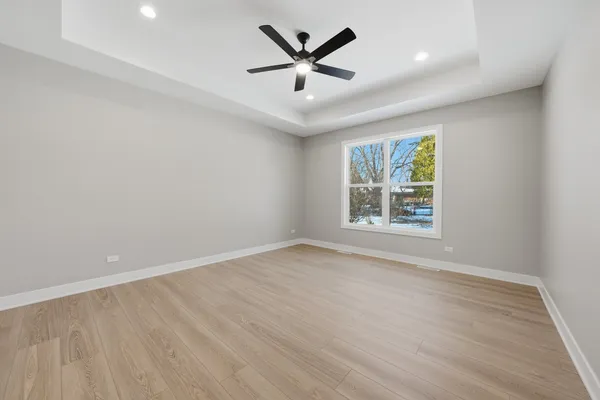 en empty room with windows and ceiling fan