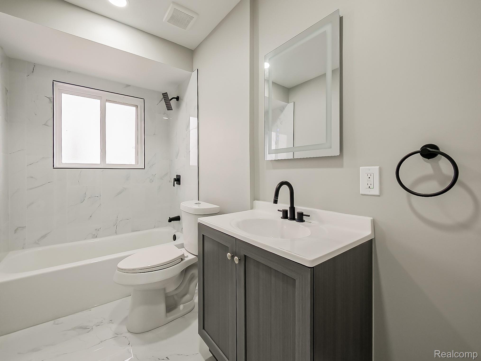 11780 Haggerty Road Belleville, MI 48111 - Photo 22 of 41 Bathroom featuring vanity, washtub / shower combination, and marble finish floors