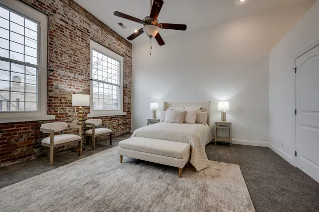 a spacious bedroom with a bed a couch and a window