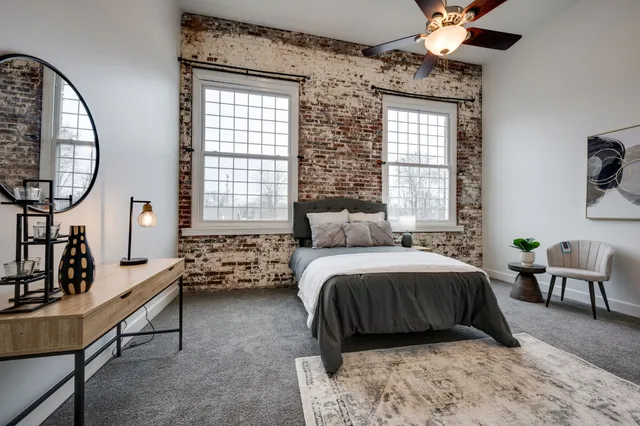 a bedroom with a bed wooden floor and window