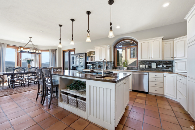 335 Bern Way Midway, UT 84049 - Photo 19 of 88 Kitchen featuring an expansive island with built-in storage, white cabinetry, integrated stainless steel appliances, and earth-toned tile flooring