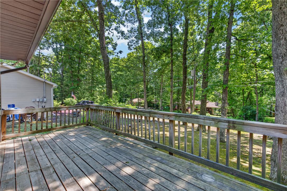 18 White Oak Road Nesquehoning, PA 18240 - Photo 7 of 52 A spacious wooden deck provides a serene outdoor living area, embraced by verdant trees.