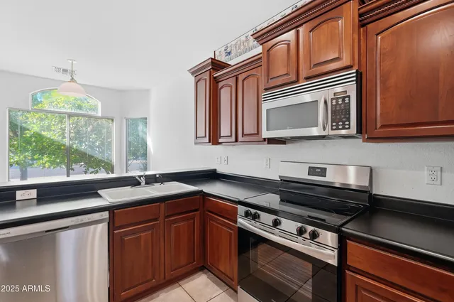 a kitchen with stainless steel appliances granite countertop a sink stove and microwave