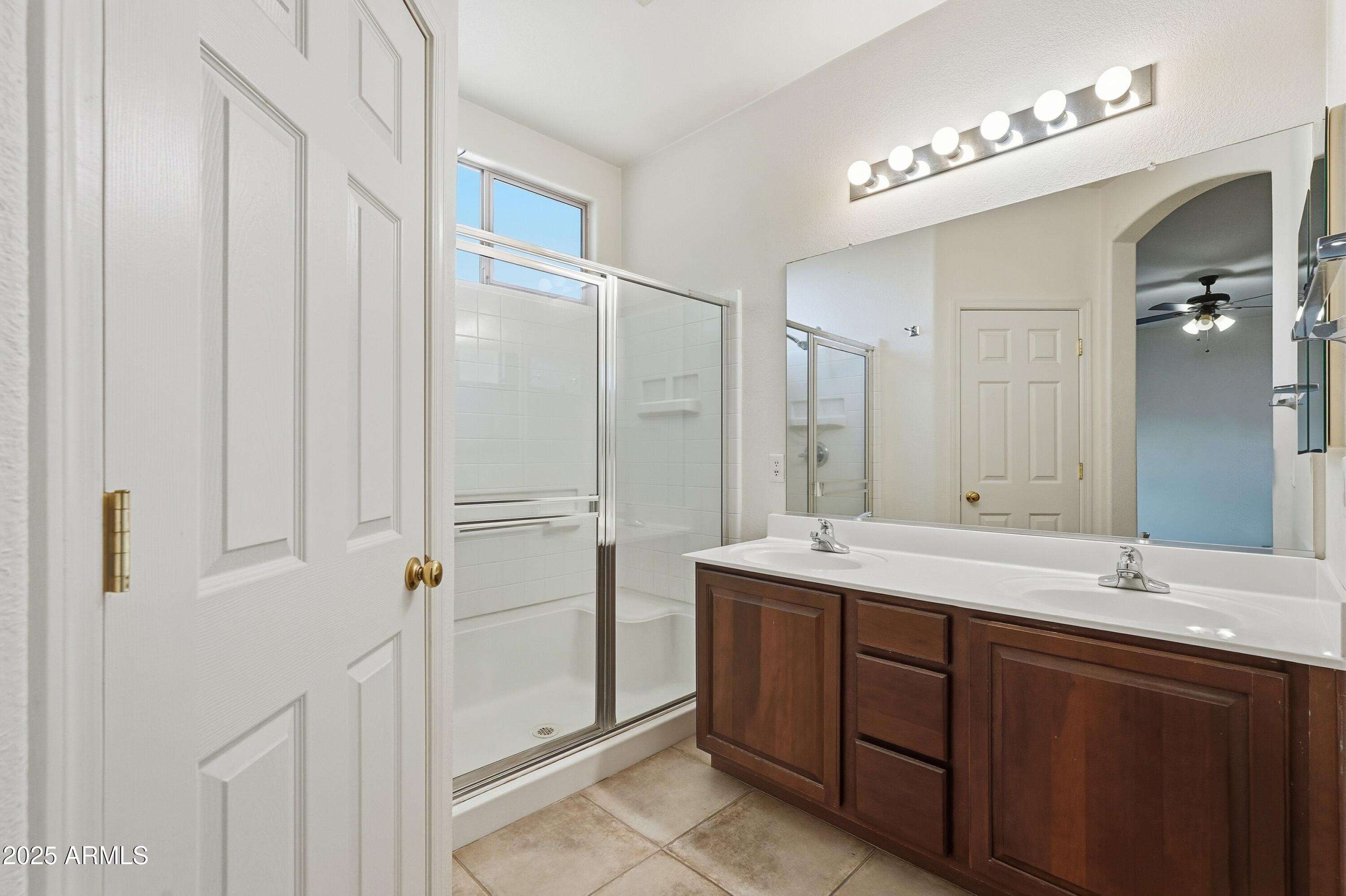 14568 West Crocus Drive Surprise, AZ 85379 - Photo 31 of 36 a bathroom with a double vanity sink and mirror with shower