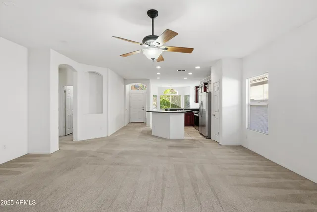 a view of a kitchen with an empty space and a ceiling fan