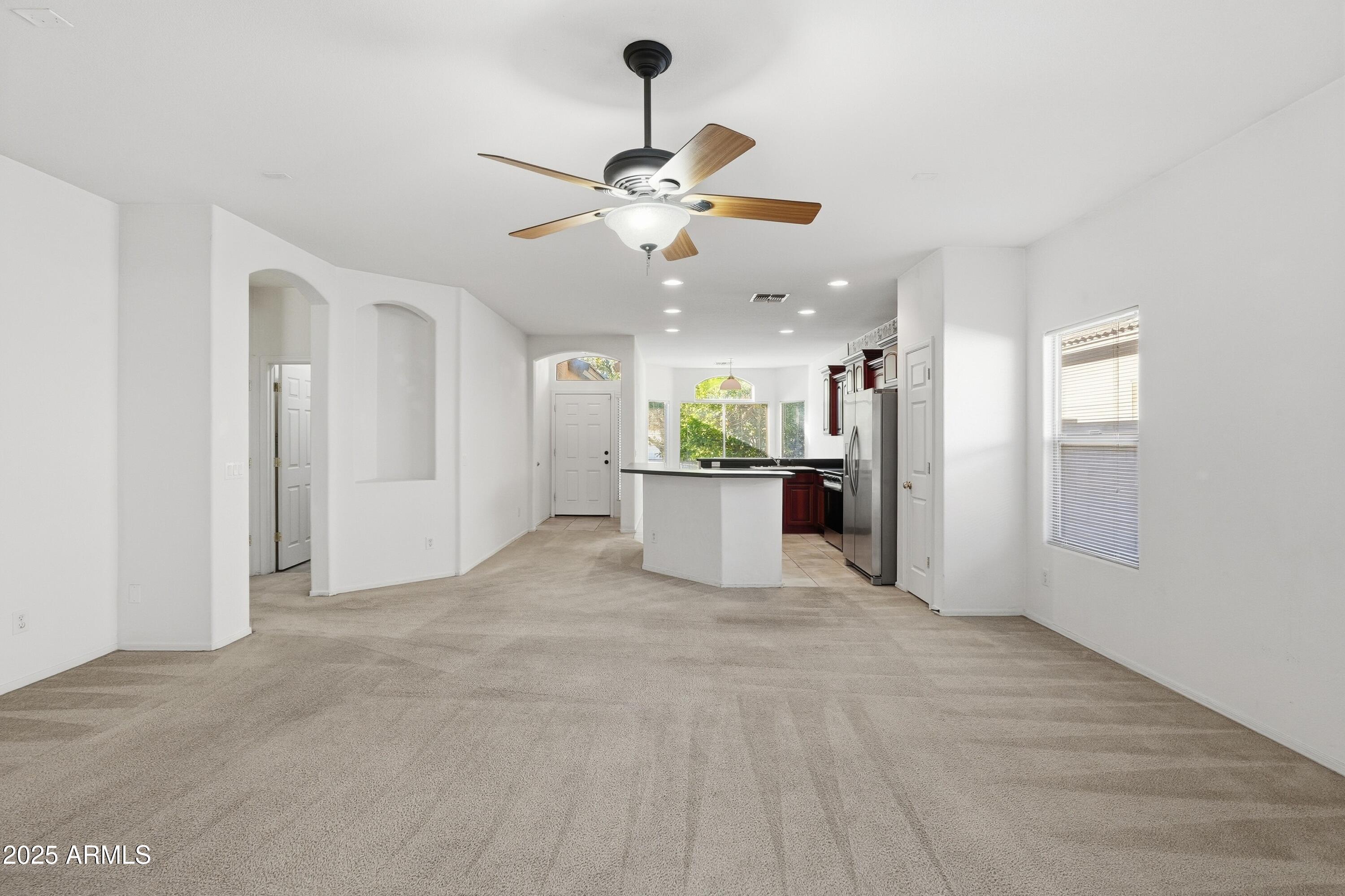 14568 West Crocus Drive Surprise, AZ 85379 - Photo 4 of 36 a view of a kitchen with an empty space and a ceiling fan