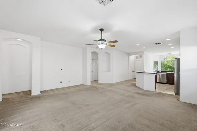 a view of an empty room and kitchen view