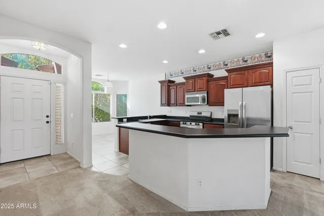 a kitchen with stainless steel appliances granite countertop a sink a stove and a refrigerator