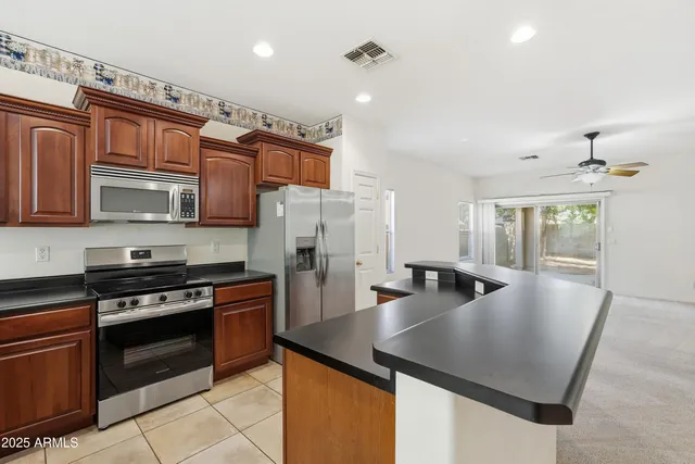 a kitchen with stainless steel appliances granite countertop a sink a stove and a refrigerator