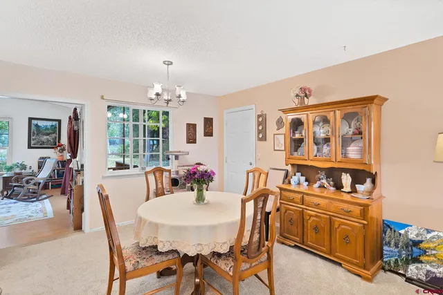 a view of a dining room with furniture and chandelier