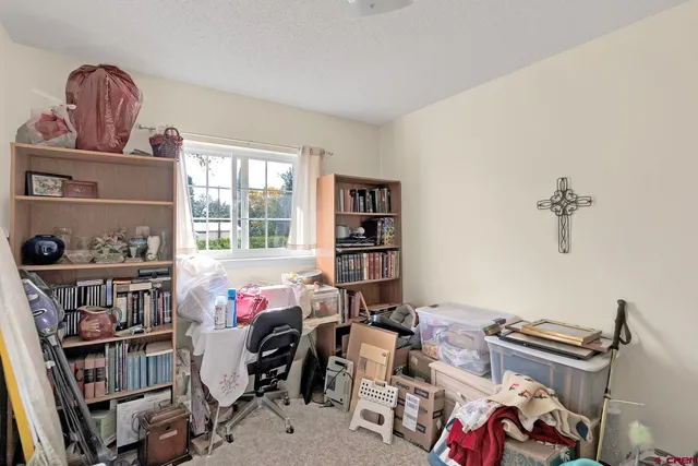 a bedroom with a bed and a bookshelf with wooden floor