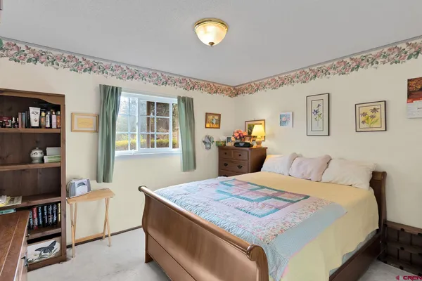 a bedroom with a bed and a painting on the wall