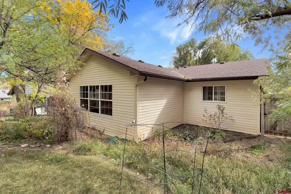 a view of a house with backyard and a tree