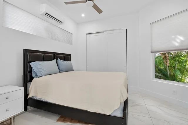 a large bed sitting in a bedroom next to a window