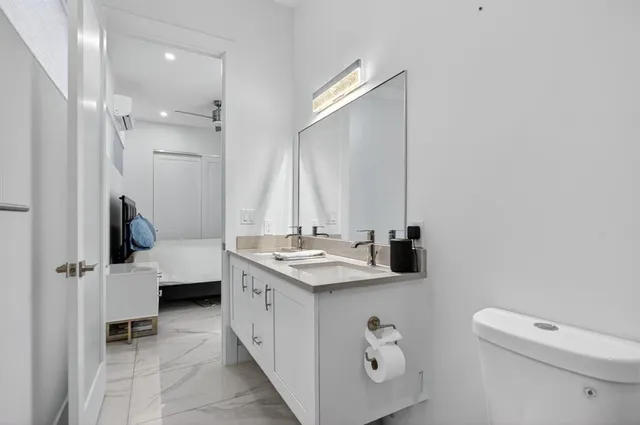 a bathroom with a sink a toilet and mirror