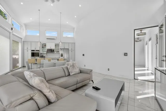 a living room with furniture and a view of kitchen