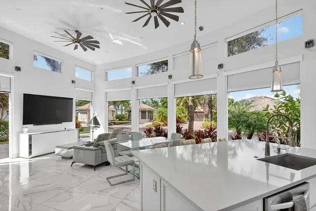 a living room with furniture a flat screen tv and a large window