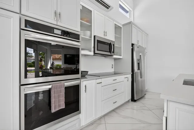 a kitchen with cabinets stainless steel appliances and sink