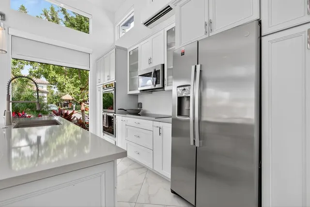 a kitchen with stainless steel appliances granite countertop a refrigerator and a sink