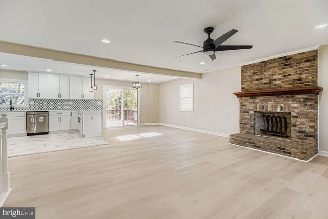 an empty room with windows and ceiling fan